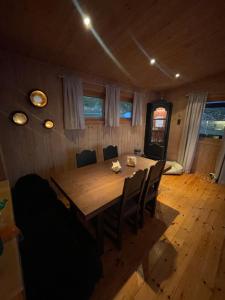 哈默菲斯特的住宿－Nordmannsneset på Seiland，一间带木桌和椅子的用餐室