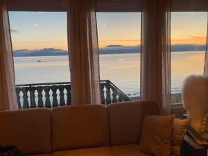 a couch in a living room with a view of the ocean at Nordmannsneset på Seiland in Hammerfest