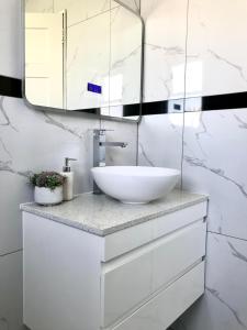 a bathroom with a white sink and a mirror at Santos Place in Auckland