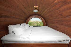 Cama en habitación de madera con ventana en Chateau Purcari, en Purcari