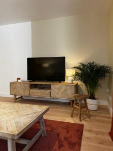un soggiorno con TV a schermo piatto su un centro di intrattenimento di Appartement Le O'mehr a Saint-Omer