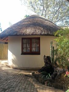 ハートビーズポートにあるHarties Lodge - Private Suiteの茅葺き屋根の小さな白い家