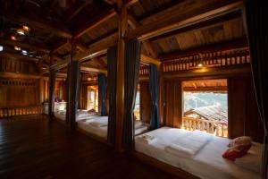 um grupo de quatro camas num quarto com janelas em O Châu Homestay Lào Cai em Lao Cai
