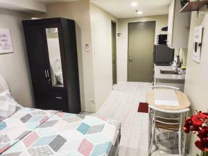 a room with a bed and a table and a kitchen at Cityscape Grand Tower Condominium in Cebu City