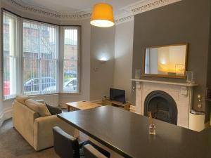 a living room with a table and a fireplace at MMR Flats in Carlisle