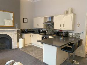 a kitchen with white cabinets and a black counter top at MMR Flats in Carlisle