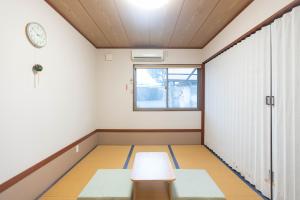 ein leeres Zimmer mit einem Tisch und einer Uhr in der Unterkunft Kobohudonoyu in Sukagawa