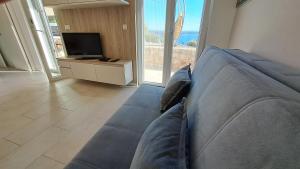 a blue couch in a living room with a television at Apartmani STJEPAN in Zavala