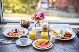 una mesa con platos de desayuno y zumo de naranja en First Hotel Planetstaden, en Lund