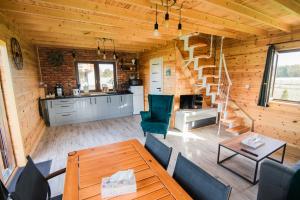 a living room with a table and chairs and a staircase at Zakątek na Mazurach I Kalinowo, Romoty in Kallinowen
