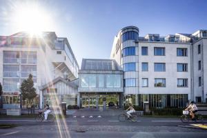 Gente montando bicicletas por una calle frente a los edificios en First Hotel Planetstaden, en Lund