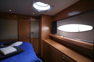 Cette chambre comprend un lit et une grande fenêtre. dans l'établissement Floatinn Boat-BnB, à Genève