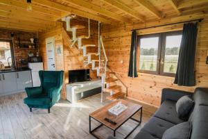a living room with a staircase in a log cabin at Zakątek na Mazurach I Kalinowo, Romoty in Kallinowen