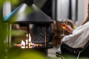 a woman holding a glass of wine next to a fireplace at First Hotel Planetstaden in Lund