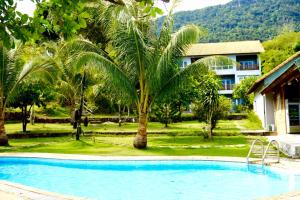 una piscina frente a un complejo con palmeras en Cosiana Resort, en Phu Quoc