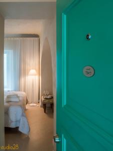a door to a bedroom with a bed and a table at Studio28 Boutique Rooms in Pärnu