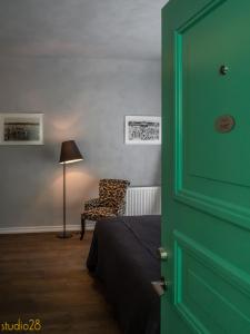 a door to a bedroom with a bed and a chair at Studio28 Boutique Rooms in Pärnu