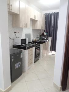 a kitchen with a stove and a microwave at Carlyle comfort home in Thika