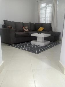a living room with a couch and a coffee table at Carlyle comfort home in Thika