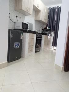 a kitchen with a refrigerator and a stove top oven at Carlyle comfort home in Thika