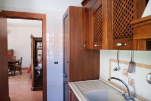 a kitchen with wooden cabinets and a sink at Grande Villa con Giardino e BBQ vicino al Mare in Mondello +34 photos