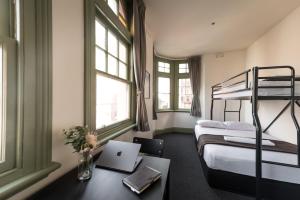 シドニーにあるシドニー セントラル インのベッド2台、ノートパソコン付きのデスクが備わる客室です。