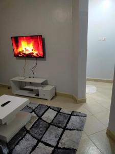 salon z telewizorem na ścianie w obiekcie Carlyle comfort home w mieście Thika
