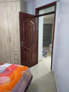 a bedroom with a large wooden door and a bed at Carlyle comfort home in Thika