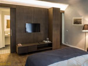sypialnia z łóżkiem i telewizorem na ścianie w obiekcie Studio28 Boutique Rooms w Parnawie