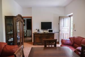 a living room with a couch and a television at Grande Villa con Giardino e BBQ vicino al Mare in Mondello