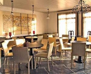 ein Restaurant mit Tischen und Stühlen in einem Raum in der Unterkunft Nastou View Hotel in Ano Poroia