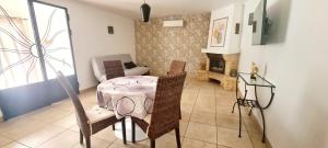 a living room with a table and chairs and a fireplace at L'Ecrin des Alpilles in Graveson