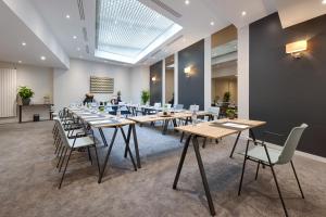 une salle de conférence avec des tables et des chaises en bois dans l'établissement Floride-Etoile, à Paris