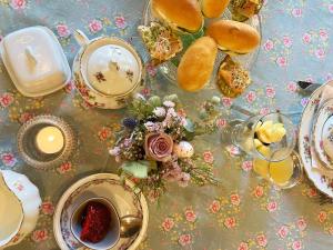 a table topped with plates and cups of tea and flowers at Amberhoeve in Schorisse +28 photos