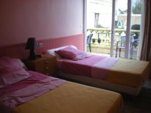 twee bedden in een kamer met een raam bij Hotel Le Cargo in Rochefort