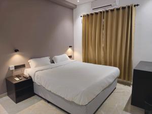 um quarto com uma cama grande e uma televisão em 7 The Business Hotel em Alwaye