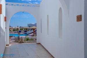 - une vue sur la piscine depuis le couloir d'une maison dans l'établissement Beach safari nubian resort, à Marsa Alam