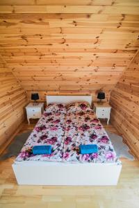 a bed in a room with wooden walls and wooden floors at Zakątek na Mazurach I Kalinowo, Romoty in Kallinowen