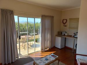 a kitchen with a sliding glass door to a balcony at Twogether self catering in Clarens