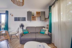 ein Wohnzimmer mit einem Sofa und einem Tisch in der Unterkunft LE MAOBI - Arboré, calme, propre - 15 min Bordeaux centre in Tresses