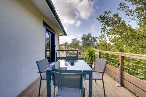 una mesa y sillas en el balcón de una casa en LE MAOBI - Arboré, calme, propre - 15 min Bordeaux centre en Tresses