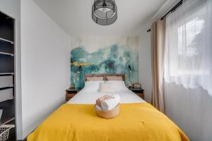 un dormitorio con una cama amarilla con sombrero en LE MAOBI - Arboré, calme, propre - 15 min Bordeaux centre en Tresses