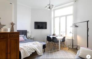 a bedroom with a bed and a desk and a table at Scandinavian Home 21 in Heard City in Helsinki