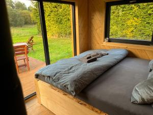 a bed in a room with a large window at Obytný kontejner Cabin Stars in Zátor