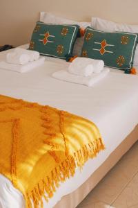 uma cama com toalhas e um cobertor amarelo em 44 Forty Four Coast - Espinho em Espinho