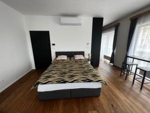 a bedroom with a bed and a wooden floor at Apartman Champion III in Pilsen