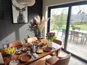 a dining room table with a deer picture on the wall at Housedurbuy 2 in Durbuy