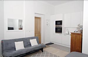 een woonkamer met een bank en een keuken bij Scandinavian Home 21 in Heard City in Helsinki