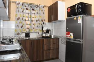 a small kitchen with a refrigerator and a stove at Airport Bliss House in Kisumu