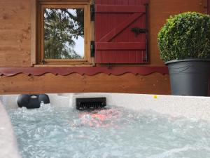 a pool of water in front of a house at le cocon d'amour " Roulotte avec jaccuzi privé " in La Chapelle-du-Fest